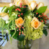 A large full vase of long-stem roses accented with dramatic hanging amaranthus