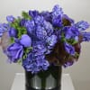 Purple hydrangeas, purple hyacinth, purple anemones  in black vase