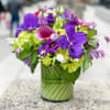 This purple and green arrangement is filled with Purple vanda orchids, green