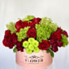 Red Roses, Green Button, with added greenery in a pink hat box.