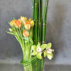 Vase with beautiful tulips, cymbidium orchids.