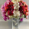 A grandiose and opulent display of coral, purple, and pink blooms of