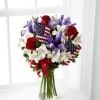 Bright red roses mingle with blue iris, white Peruvian lilies and assorted