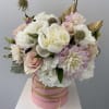 Pink and white bouquet in a round pink box with gold ribbon