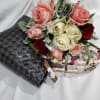 a bouquet of roses with fillers and a unique hand-woven tote bag