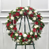 A beautiful wreath of crimson red and white carnations, accented with babies
