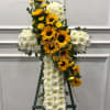 An all white cushion cross with a cluster of sunflowers and viking