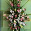 Pink Paradise Spray includes tropical lilies and colorful tropical leaves in shades