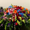 A mixture of seasonal bold flowers for casket. 