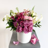 Lavender roses, Purple Peruvian lilies, delicate white stock, and more are arranged