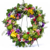 A vibrant circle of our seasons finest blossoms, including orchids, carnations, green