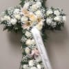 The cross is made of roses, lilies, carnations and Babies Breath