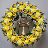 This wreath of yellow daisies and carnations with babies breath with a