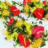 A trio of tropical centerpieces filled with colorful tropical blooms (based on