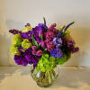 a low and lush arrangement with a beautiful combination of purple flowers