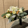 This wrist corsage is made up of white spray roses, peach hypericum