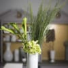 Calla lilies, scotch broom, hydrangea, &amp; cymbidium orchids in a white glass