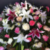 A casket spray filled with an assortment of different shades of pink