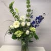 An elegant green, white and blue arrangement beautifully arranged in a tall