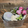 A decorative planting container filled with a large Voluspa candle, bar of