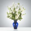 This arrangement includes white iris, white stock, white snapdragons, and queen anne&#039;s