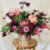 a whimsical bespoke design of ferns, orchids, tulips, &amp; unique blooms, 