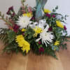 A simple mixed flower arrangement of  seasonal flowers with an angel