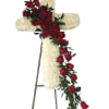 A breathtaking easel standing cross arrangement of white and red blooms remembers