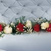 White and red mini carnations are woven into baby&#039;s breath to form