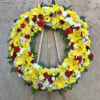 Radiating standing spray funeral arrangement with mixed yellow and red flowers with