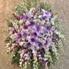 Beautiful standing funeral spray arrangement with purple and white mixed flowers. Featuring