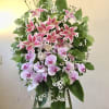 Beautiful standing funeral spray of pink and lavender flowers with green and