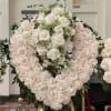 A heart shaped beautiful arrangement with white roses green cymbedeums and green