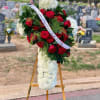 White carnations with Red roses and greens. Stand included. 