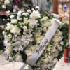 White heart filled with roses, lilies, carnations offset by a spray on