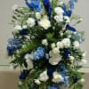 Standing spray of blue and white flowers.