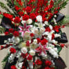 A large sympathy spray arrangement with red carnations, mixture of roses and