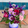 pink and purple flowers arranged inside a flower box with dragonfly on