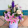 pink and purple flowers arranged inside a flower box with dragonfly on