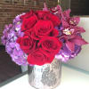 Red roses, purple hydrangea and burgundy cymbidium orchid blooms come together in