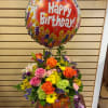 Mixed cut arrangement with orange roses, pink roses, yellow daisies, purple tulips