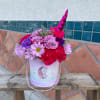Pink and lavender flowers arranged inside a unicorn box. 
mixed flowers of
