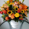 Basket with orange and yellow flowers like a sunflowers, daisies, roses, lilies