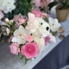 This gorgeous arrangement has white carnations, white orchids, pink roses, and fresh