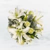 This arrangement includes white roses, white asiatic lilies, white stock, and dusty