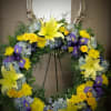 yellow lilies and blue iris- spring eternal in this tribute wreath
accented with