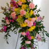 This crescent style floral tribute features green hydrangeas, pink carnations,
yellow daisies and