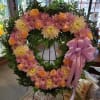 This splendid heart-shaped wreath displays lovely shades of peach roses, lavender daisies