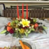 A long low table arrangement of mixed flowers such as roses, mums