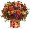 This radiant arrangement includes orange roses, light orange alstroemeria, purple button spray
